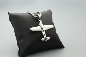 Colgante de avión pulido con cadena de metal sobre fondo de cuero negro elegante