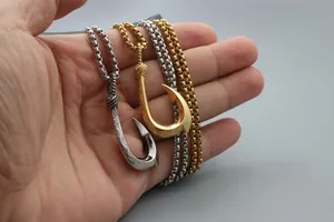 Detailaufnahme von Fischhaken-Anhängern in Gold und Silber mit feiner Wellengravur