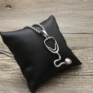 Silver stethoscope pendant necklace on black display cushion with polished steel finish