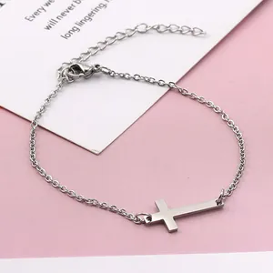 Detail eines Armbands aus Edelstahl mit Kreuzanhänger und verstellbarem Karabinerverschluss