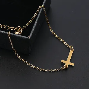 Nahaufnahme der goldenen Edelstahl-Halskette mit liegendem Kreuz und schwarzer Schmuckbox