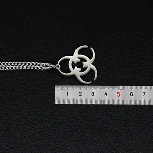 Gros plan du pendentif biohazard en acier de 30mm avec règle pour mesurer la taille