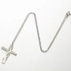 Détail du pendentif croix en argent évidé avec des motifs complexes de vignes