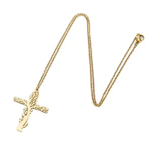 Détail du pendentif croix dorée avec découpe arbre de vie et fermoir mousqueton