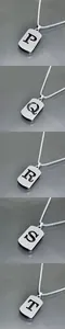 Vue détaillée de pendentifs rectangulaires argentés avec lettres P Q R T sur chaînes