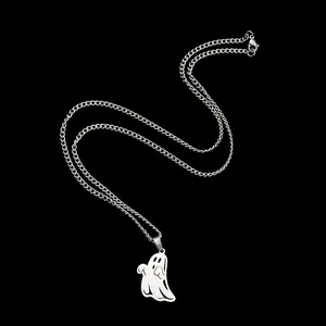 Macro detail of a silver ghost pendant on a link chain against a black background