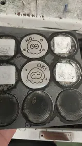 Detail view of round stainless steel decision coin with cartoon octopus and NO design