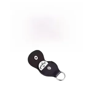 Detail of black leather guitar pick keychain holder with white stitching and custom metal coin