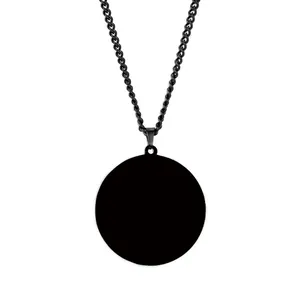 Macro detail of minimalist black stainless steel round pendant necklace on white background