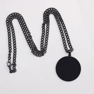 Detail of minimalist matte black stainless steel chain with a large circular pendant