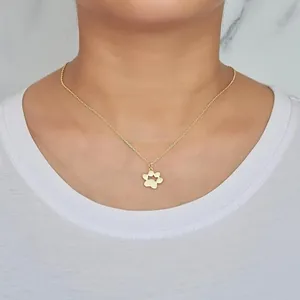 Collana minimalista in acciaio al titanio dorato con ciondolo a zampa e osso