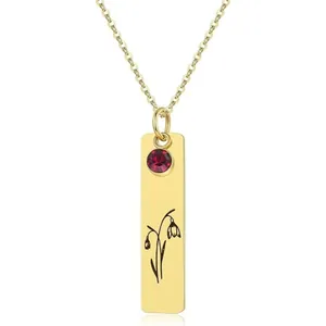 Detailed view of a gold rectangular pendant featuring a red gemstone and floral engraving