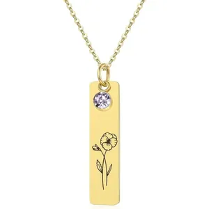 Close-up of gold-plated stainless steel bar necklace with purple gem and flower engraving