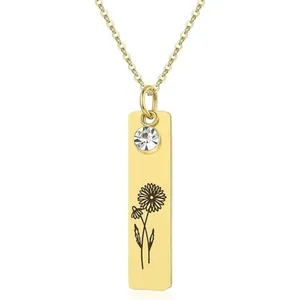 Detail showing gold rectangular necklace pendant with daisy engraving and small zircon stone