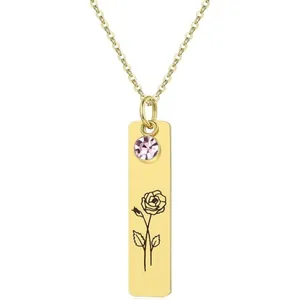 Detail view of gold rectangle necklace featuring pink crystal and rose flower engraving