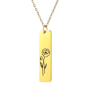 Detailed view of rectangular gold pendant with minimalist black flower engraving and chain