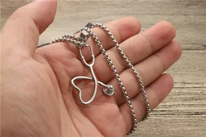 Detaillierte Nahaufnahme eines herzförmigen Stethoskop-Anhängers an einer Stahlkette