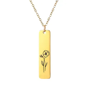 Detailed view of a gold bar pendant necklace featuring a minimalist black flower engraving