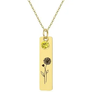 Detailed view of rectangular gold pendant with sunflower engraving and yellow gemstone
