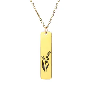 Detail of gold rectangular pendant with lily of the valley engraving on a fine chain