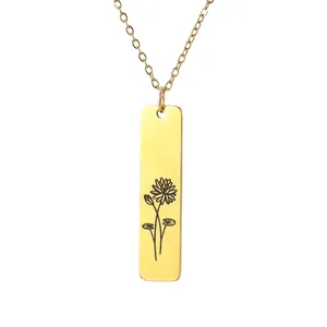 Close-up of golden rectangular bar pendant with fine flower engraving on a thin chain