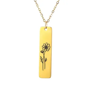 Macro detail of a rectangular gold pendant with a delicate floral engraving and fine chain
