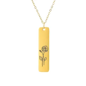 Macro view of gold rectangular bar pendant with delicate rose flower engraving on fine chain