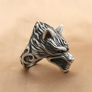 Anillo vintage de acero inoxidable con cabeza de lobo tallada sobre fondo de seda