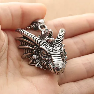 Retro stainless steel dragon head pendant showing detailed texture and size in palm