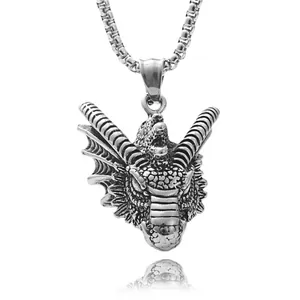 Detailed close-up of a vintage dragon head pendant with intricate scales and metallic finish