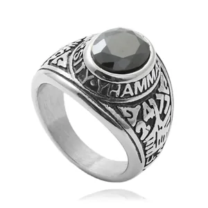 Detailopname van vintage titaniumstalen ring met zwarte edelsteen en reliëfletters