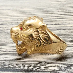 Macro detail of a vintage gold tiger head ring with red rhinestone eyes and textured fur