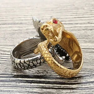 Dettaglio degli anelli a drago vintage in argento e oro con pietre rosse negli occhi
