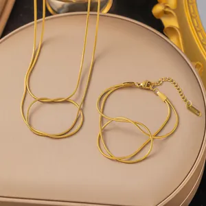 Gouden roestvrijstalen slangenketting en armband set met minimalistisch knoopontwerp