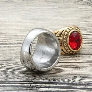 Vintage stainless steel ring set featuring a large red gemstone on a wood background