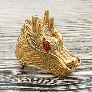 Detailansicht eines goldenen Drachenrings mit feinen Schuppen und roten Edelsteinaugen