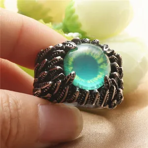 Dettaglio dell'anello punk in acciaio con pietra occhio verde e incisione a piume