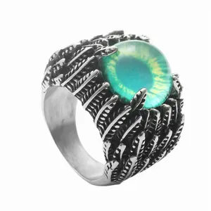 Dettaglio dell'anello punk in acciaio con piuma e pietra verde occhio del diavolo