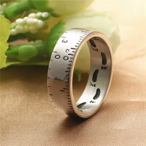 Vintage ruler-style stainless steel ring with laser-engraved numeric and footprint motifs
