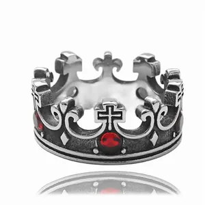 Primer plano de anillo de corona gótica con piedras rojas y acero estilo vintage