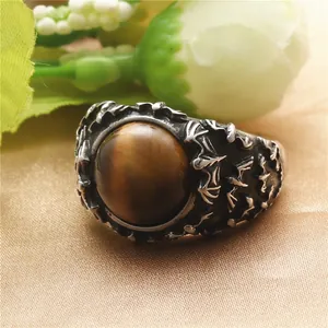 Macro shot of tiger eye stone ring with vintage gothic bat carvings on stainless steel