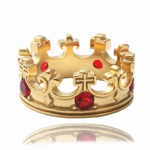 Detalle de un anillo de corona dorado con piedras rojas y tallas de metal de flores de lis
