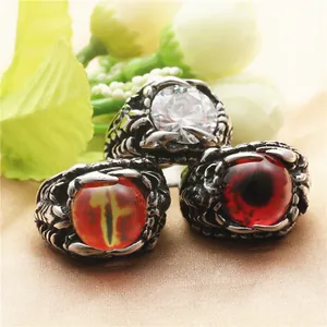 Punk dragon claw rings set with red and yellow eye stones on gold satin background