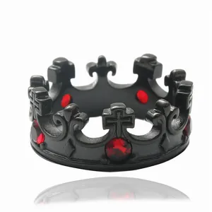 Detalle de anillo de corona gótica en acero negro con piedras rojas y grabados de cruz