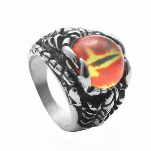 Detail of vintage punk dragon claw ring in stainless steel with a red dragon eye stone
