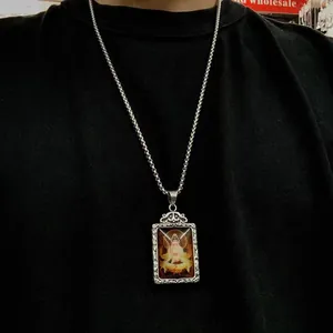 Primer plano de un colgante vintage de acero inoxidable con diseño de Buda Guanyin