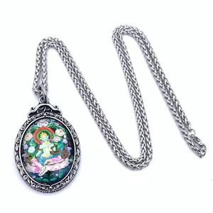 Macro detail of Green Tara Thangka painting pendant with vintage steel frame and rope chain