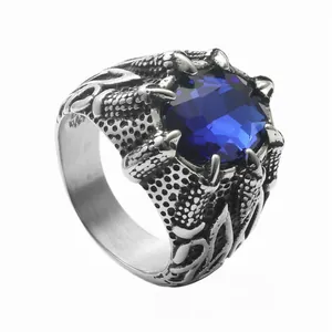 Macro detail of vintage dragon claw ring holding a faceted blue crystal stone