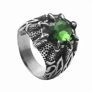 Detail of vintage dragon claw ring featuring a large green stone and scale texture