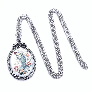 Macro detail of retro stainless steel pendant with colorful koi and lotus relief